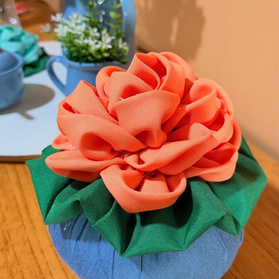 Detalhe aproximado da flor de pano coral, mostrando dobras e textura do tecido